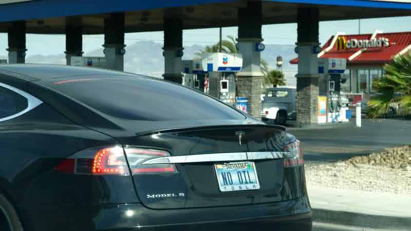 Tesla Model S with a gas pump in the background